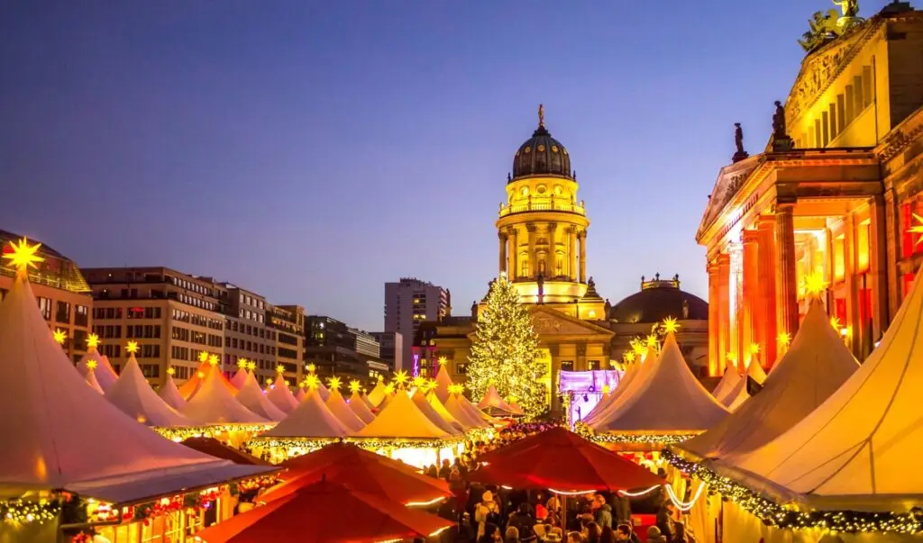 Kerstmarkt tijdens een winterse roadtrip door Europa bij avondlicht