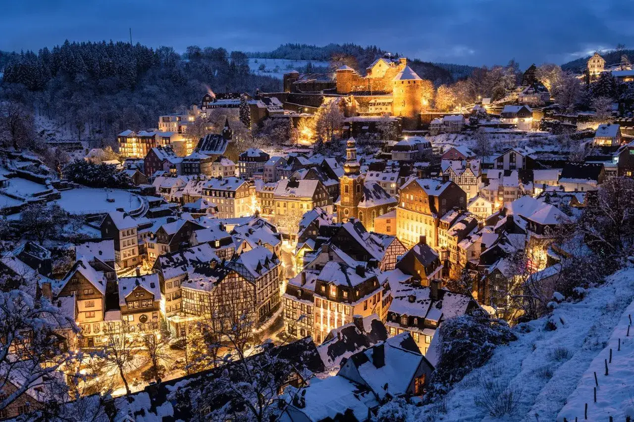 Sneeuwachtig Monschau bij avondlicht tijdens een winterse kerstmarkt roadtrip